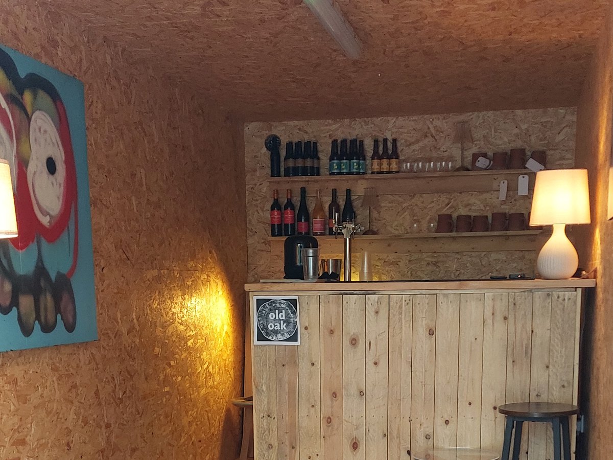 The timber bar inside the taproom, bottles on the shelf and a rug on the floor